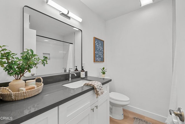 bathroom featuring vanity, baseboards, a shower with curtain, toilet, and wood finished floors