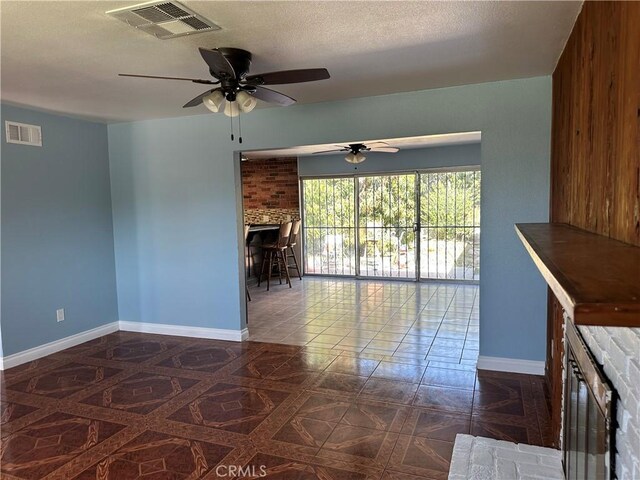878 E Holly St, Rialto, CA 92376 - unfurnished living room featuring a ceiling fan, a fireplace, and a textured ceiling
