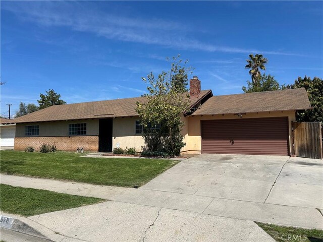 878 E Holly St, Rialto, CA 92376 - ranch-style house with stucco siding, a garage, driveway, a chimney, and brick siding
