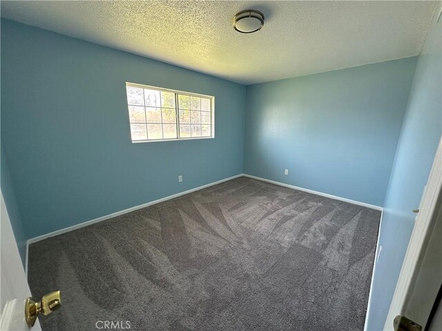 878 E Holly St, Rialto, CA 92376 - empty room with dark colored carpet and a textured ceiling