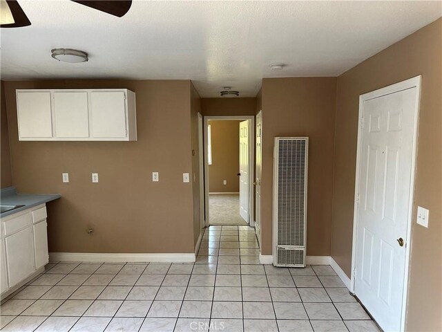 878 E Holly St, Rialto, CA 92376 - kitchen with a heating unit, white cabinetry, light tile patterned flooring, and a ceiling fan