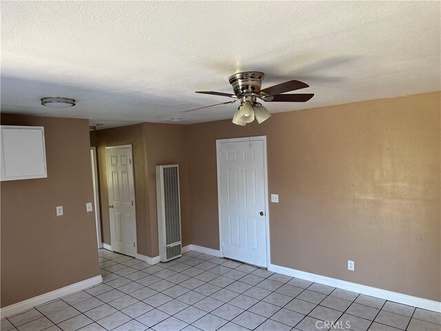 878 E Holly St, Rialto, CA 92376 - unfurnished room with a heating unit, ceiling fan, light tile patterned floors, and a textured ceiling