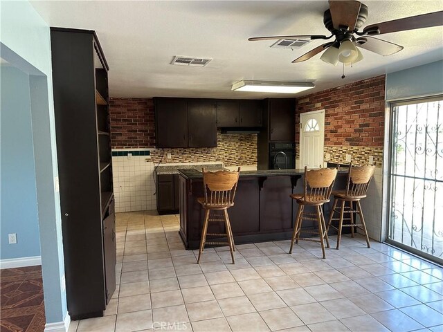 878 E Holly St, Rialto, CA 92376 - kitchen featuring a peninsula, light tile patterned flooring, a kitchen bar, and a ceiling fan