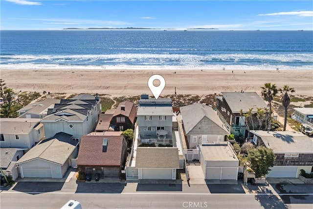 drone / aerial view with a water view, a view of the beach, and a residential view