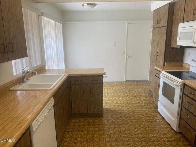 1208 Village 1 Unit 1208, Camarillo, CA 93012 - kitchen featuring white appliances, dark flooring, light countertops, and a peninsula