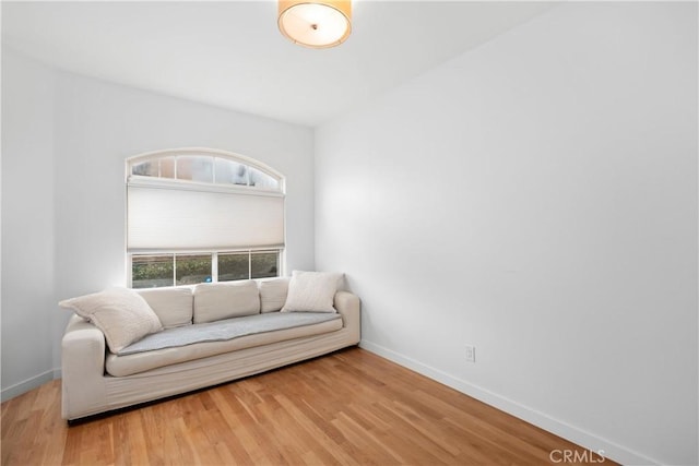 sitting room with baseboards and wood finished floors