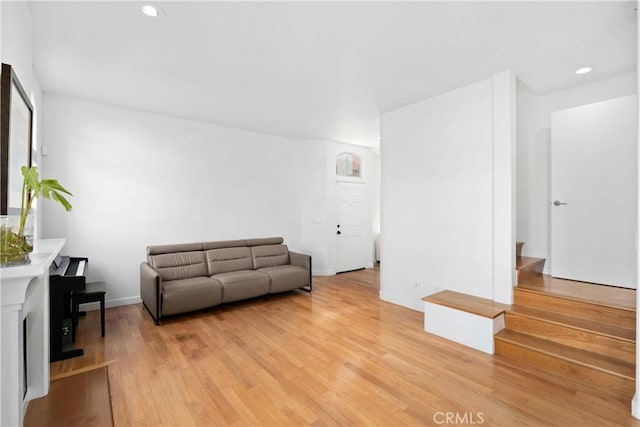 living area with recessed lighting, baseboards, and light wood-type flooring