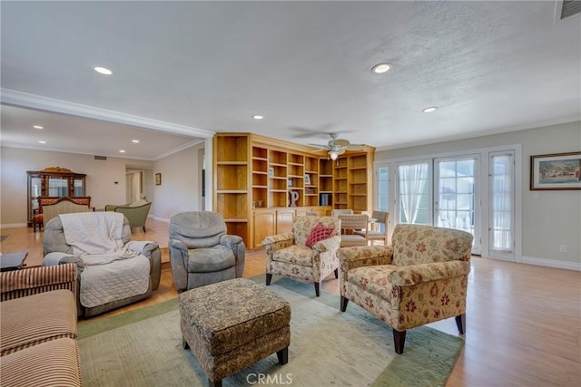 living area featuring recessed lighting, visible vents, a ceiling fan, crown molding, and baseboards