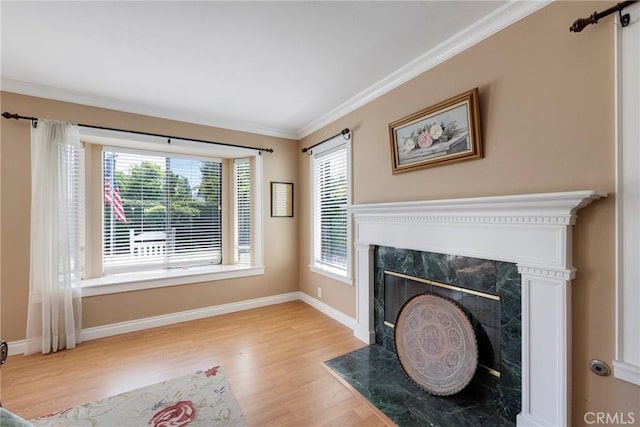 unfurnished living room with baseboards, crown molding, wood finished floors, and a wealth of natural light