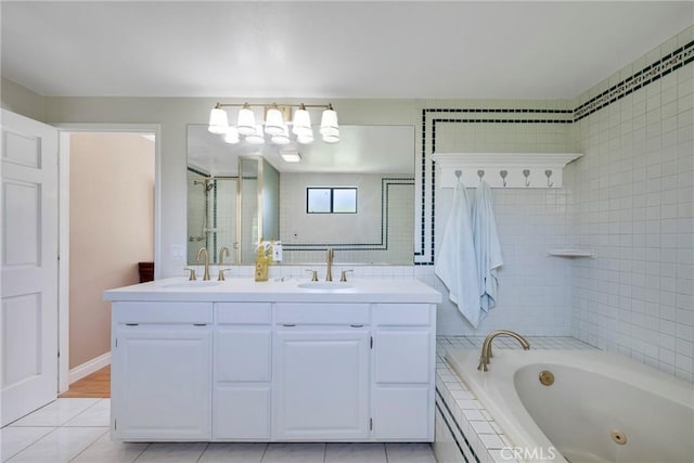 full bath featuring double vanity, tile patterned floors, a tub with jets, and a sink