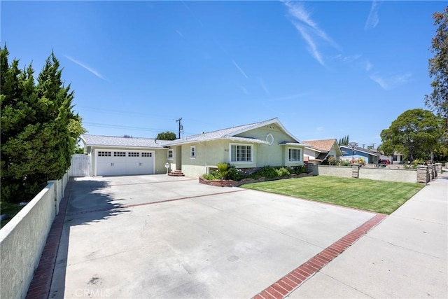 ranch-style home featuring a front lawn, concrete driveway, fence, an attached garage, and stucco siding