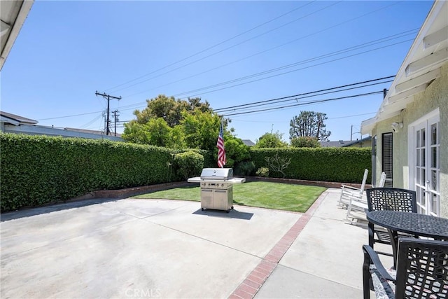 view of patio featuring area for grilling, a fenced backyard, and outdoor dining space