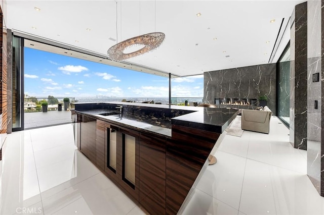 kitchen with a high end fireplace, tile patterned floors, floor to ceiling windows, and modern cabinets