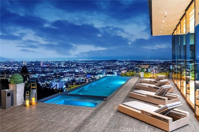view of swimming pool featuring a view of city and an in ground hot tub