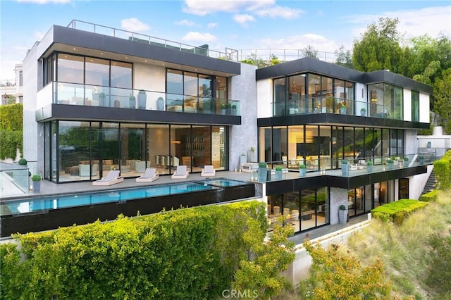 back of house featuring an outdoor pool and a patio area