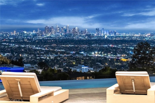 view of pool featuring a view of city lights