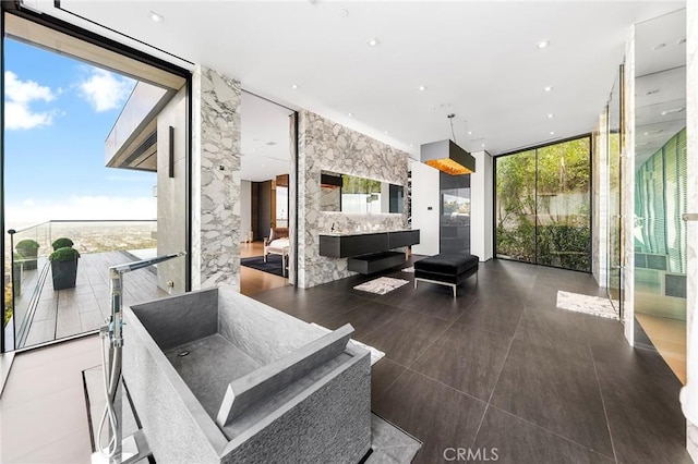 living area with expansive windows, a wealth of natural light, and tile patterned floors