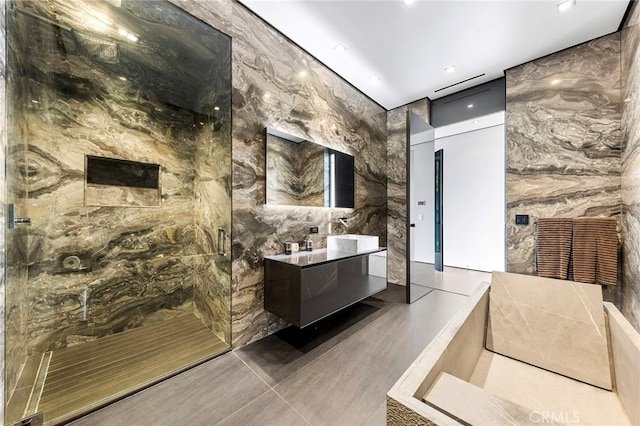 bathroom with double vanity, recessed lighting, tile walls, and a marble finish shower