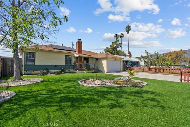 view of front of property with fence, an attached garage, a chimney, concrete driveway, and solar panels