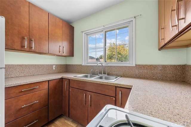 kitchen featuring light countertops, a sink, and stove