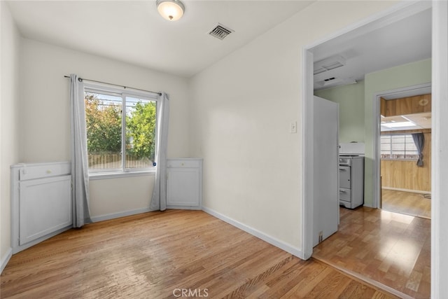 empty room with baseboards, visible vents, and light wood-style flooring