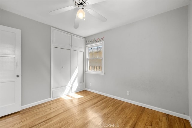 unfurnished bedroom with light wood finished floors, baseboards, and a closet