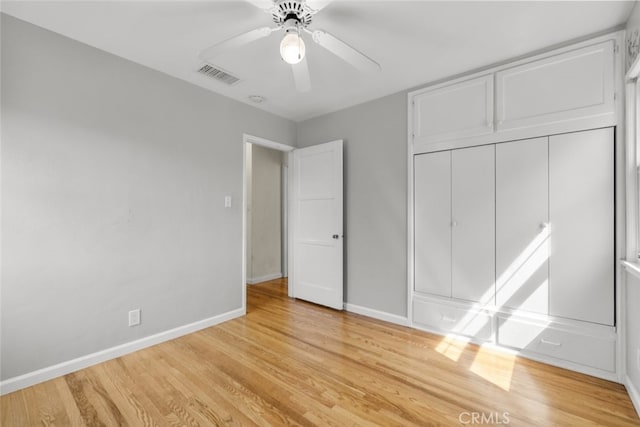 unfurnished bedroom featuring a closet, baseboards, light wood finished floors, and visible vents