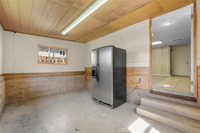 basement with wooden ceiling and fridge with ice dispenser