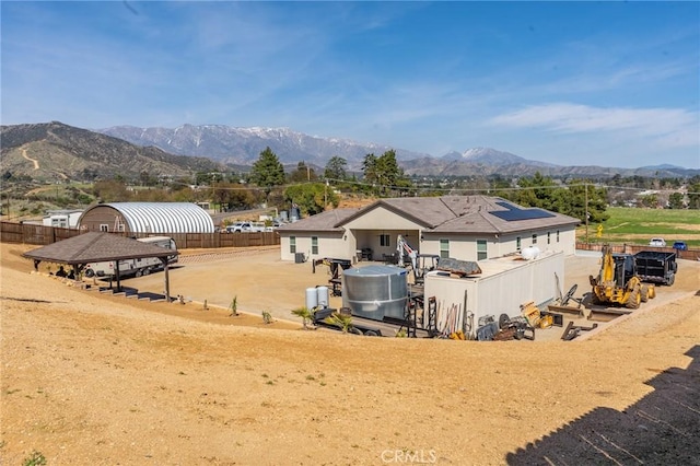 rear view of property with fence and a mountain view