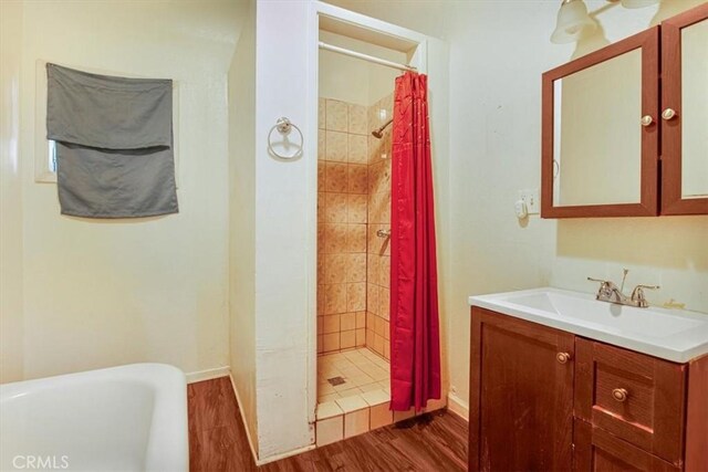 3417 4th Ave, Los Angeles, CA 90018 - bathroom with baseboards, a tub, a shower stall, vanity, and wood finished floors