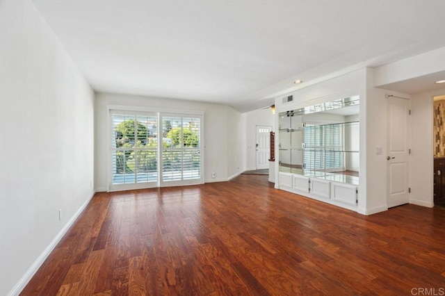 unfurnished living room with baseboards, visible vents, and wood finished floors
