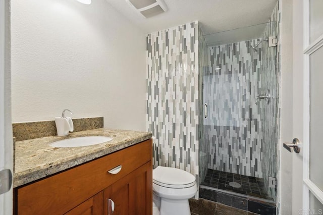 bathroom with vanity, a shower stall, and toilet