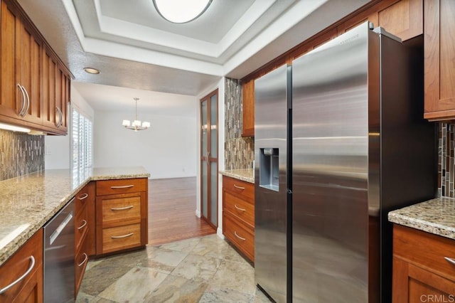 kitchen with decorative backsplash, brown cabinets, and stainless steel appliances