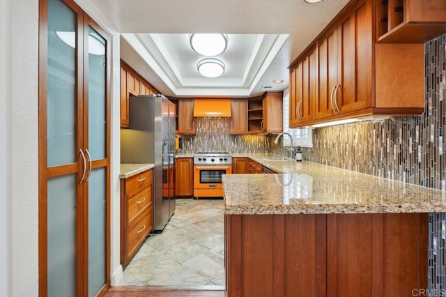 kitchen featuring a sink, open shelves, stainless steel appliances, and brown cabinets