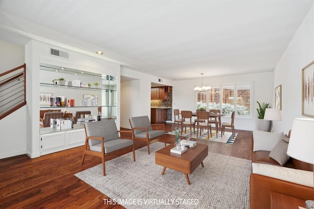 living room featuring visible vents, baseboards, dark wood-type flooring, and a chandelier