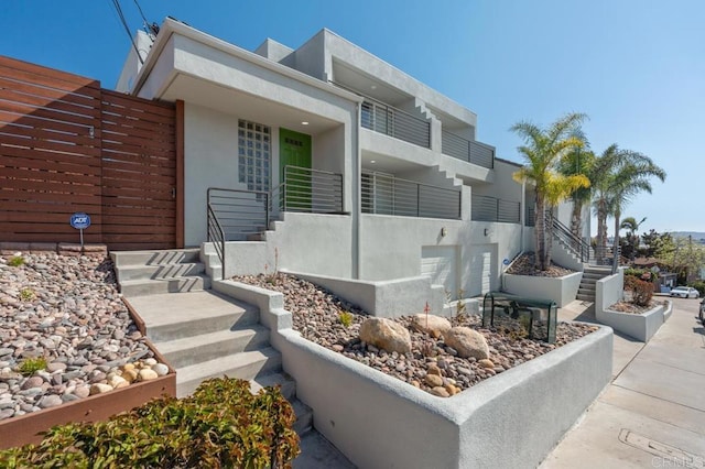 exterior space with stairs and stucco siding
