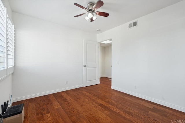 empty room featuring baseboards, a ceiling fan, wood finished floors, and visible vents