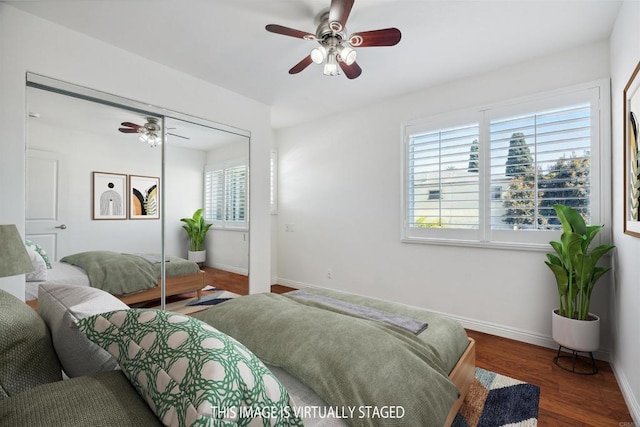 bedroom with a closet, a ceiling fan, baseboards, and wood finished floors