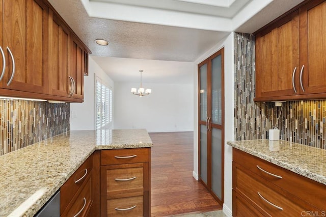 3521 Andrews St, San Diego, CA 92103 - kitchen with brown cabinets, tasteful backsplash, wood finished floors, and light stone countertops