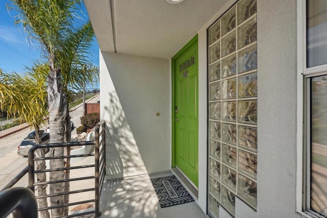 doorway to property featuring stucco siding and covered porch
