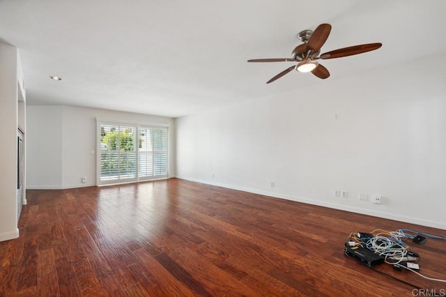 unfurnished room featuring baseboards, ceiling fan, and wood finished floors