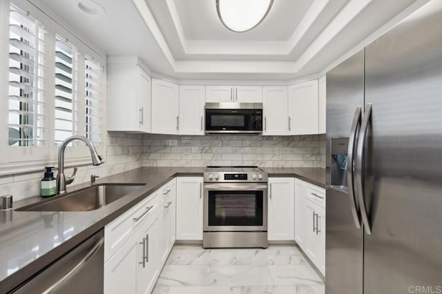 kitchen featuring a sink, white cabinets, stainless steel appliances, and marble finish floor