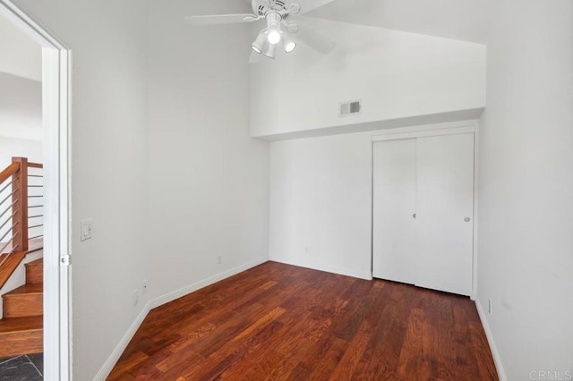 unfurnished bedroom featuring visible vents, a closet, wood finished floors, baseboards, and ceiling fan