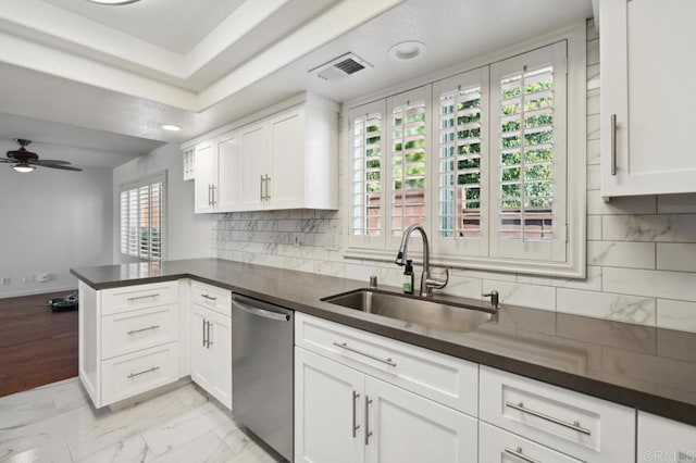 kitchen with a ceiling fan, visible vents, dark countertops, stainless steel dishwasher, and a sink
