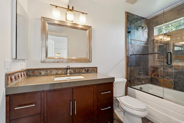 full bath featuring vanity, enclosed tub / shower combo, and toilet