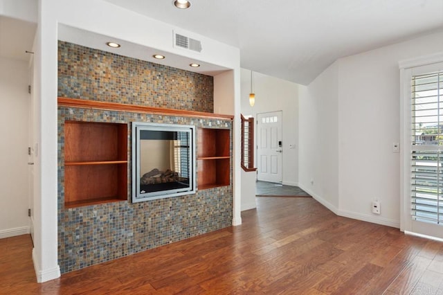 unfurnished living room featuring baseboards, recessed lighting, wood finished floors, and visible vents