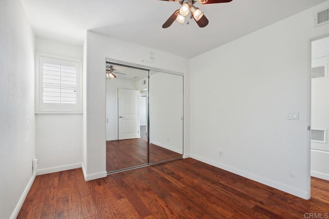 unfurnished bedroom with baseboards, wood finished floors, visible vents, and a closet