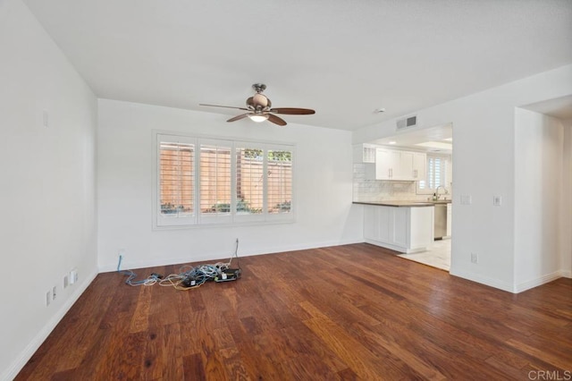 unfurnished living room featuring baseboards, ceiling fan, wood finished floors, and visible vents