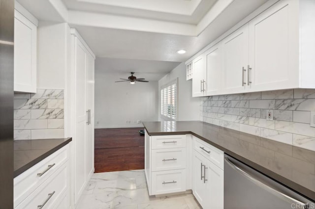 kitchen featuring ceiling fan, dark countertops, dishwasher, a peninsula, and white cabinetry