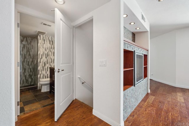hall featuring recessed lighting, wood finished floors, and visible vents